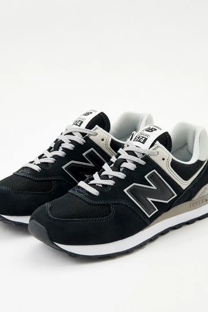 The camera slowly moves in on a pair of black suede sneakers.